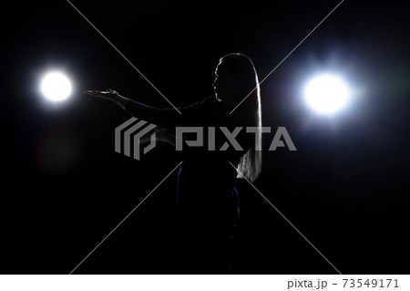 Silhouette of woman posing isolated on dark background in lanterns light Silhouette of woman posing isolated on dark background in lanterns light 73549171