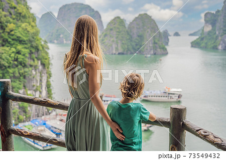 Mom and son travelers in Halong Bay. Vietnam. Travel to Asia, happiness emotion, summer holiday concept. Picturesque sea landscape. Ha Long Bay, Vietnam. After coronavirus COVID 19 73549432
