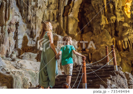 Mom and son tourists in Hang Sung Sot Grotto Cave of Surprises, Halong Bay, Vietnam. Traveling with children concept. Tourism after coronavirus 73549494
