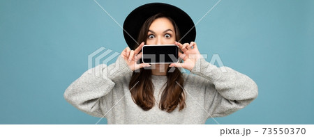 panoramic Photo of Beautiful positive young female person wearing black hat and grey sweater holding panoramic Photo of Beautiful positive young female person wearing black hat and grey sweater holding 73550370