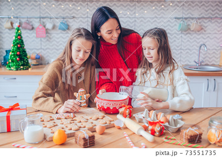 Happy family mother and daughter bake cookies for Christmas Happy family mother and daughter bake cookies for Christmas 73551735