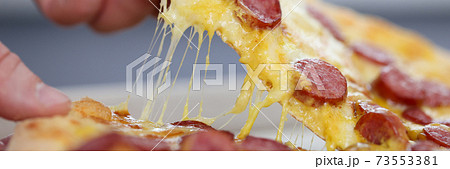 Man's hand holds a slice of pizza. Man's hand holds a slice of pizza. 73553381