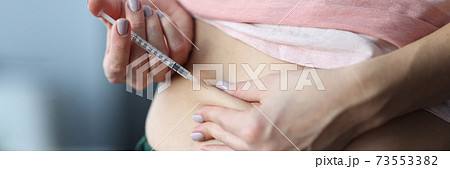 Woman gives an injection in the stomach. 73553382