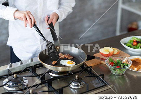 キッチンで朝食を作る男性 73553639