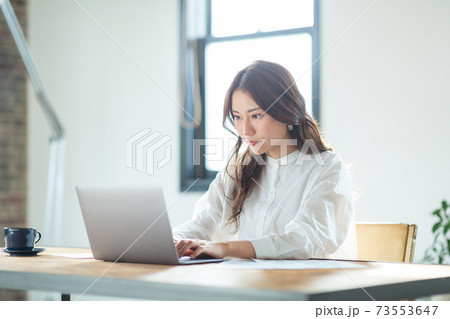 リビングでパソコンをする若い女性 73553647