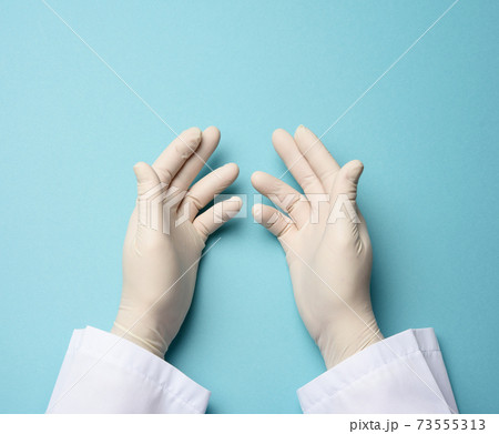 two male hands in white latex gloves, doctor's palms on a blue background 73555313