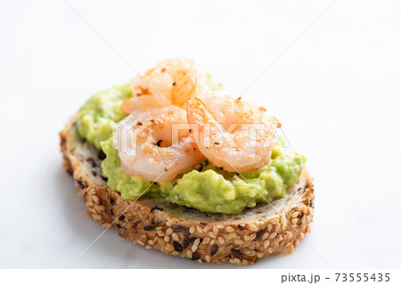 Appetizer toast or bruschetta with avocado cream and shrimps 73555435