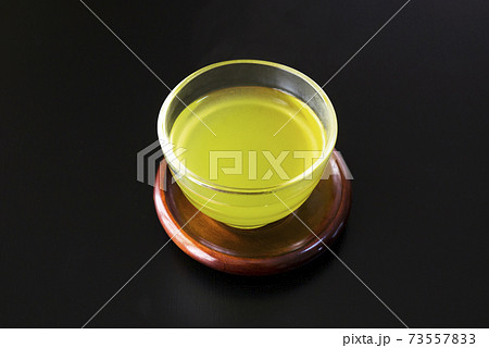 黒い背景のガラスの湯吞みに入った緑茶 黒い背景のガラスの湯吞みに入った緑茶 73557833
