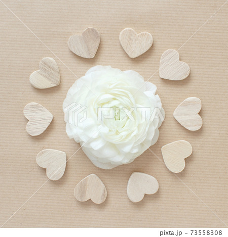 Cream flower in a circle of hearts on beige paper 73558308