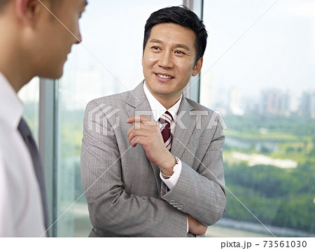 two asian businessmen standing and talking in office 73561030