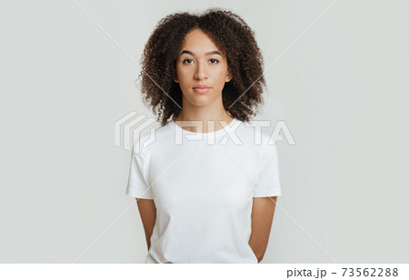 Serious, calm, strict emotions. Emotionless, unemotionally young african american woman holds her hands behind back 73562288