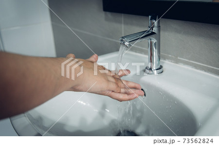 Men are washing their hands in the sinks to clear respiratory bacteria and viruses, sanitation and reduce the spread of COVID-19 that is spread around the world, Hygiene ,Sanitation concept. Men are washing their hands in the sinks to clear respiratory bacteria and viruses, sanitation and reduce the spread of COVID-19 that is spread around the world, Hygiene ,Sanitation concept. 73562824