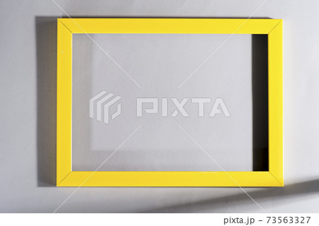 Yellow frame with shadows on grey background. Trendy colors 2021. Yellow frame with shadows on grey background. Trendy colors 2021. 73563327