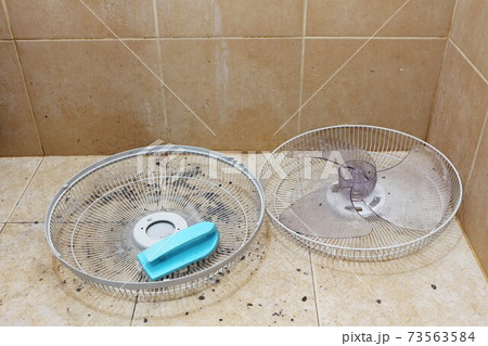 Cleaning parts of a fan in the washing room. 73563584
