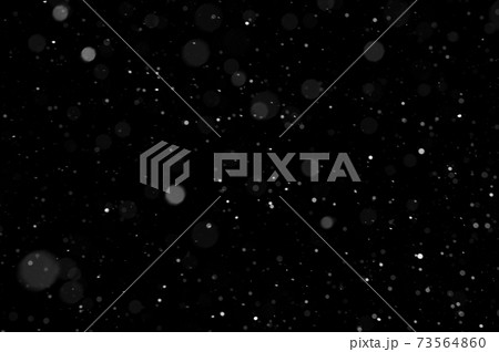 Bokeh of white snow on a black background. Snowfall - design element. 73564860