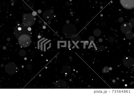 Bokeh of white snow on a black background. Snowfall - design element. 73564861