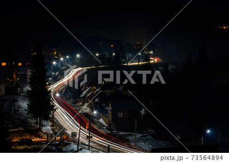 Magnificent night landscape of the Ukrainian village in bright light and blurred automobile lights Magnificent night landscape of the Ukrainian village in bright light and blurred automobile lights 73564894