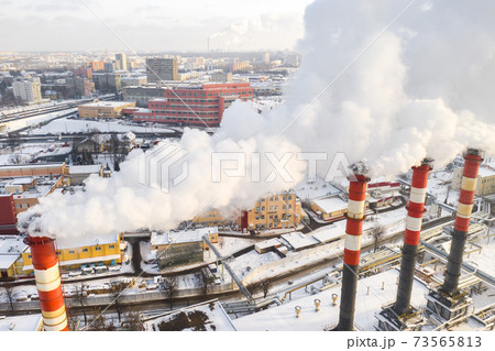 In the winter city, the factory's chimneys are smoking. The concept of air pollution. Environmental pollution by industrial waste In the winter city, the factory's chimneys are smoking. The concept of air pollution. Environmental pollution by industrial waste 73565813