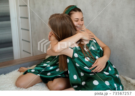 Lifestyle, friendship concept - two beautiful girls dressed in pajamas hugging Lifestyle, friendship concept - two beautiful girls dressed in pajamas hugging 73567257