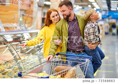 cheerful couple, parents with restless son in grocery store 73568663