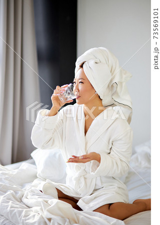 healthy young asian woman taking pills and a glass of water for treatment healthy young asian woman taking pills and a glass of water for treatment 73569101