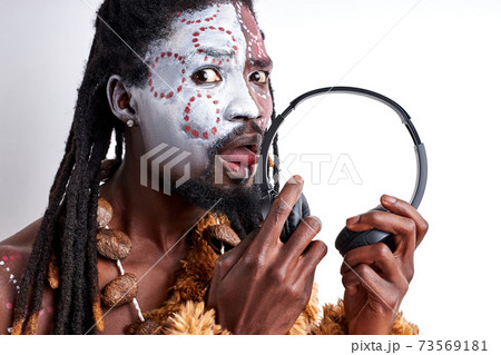 young primitive african native man tastes headphones, licks it young primitive african native man tastes headphones, licks it 73569181