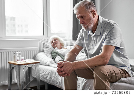 upset pensioner man sits in depression while her sick woman suffering from covid-19 upset pensioner man sits in depression while her sick woman suffering from covid-19 73569305