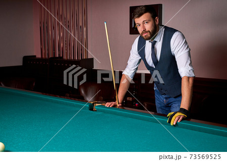 portrait of caucasian male standing next to billiards table 73569525