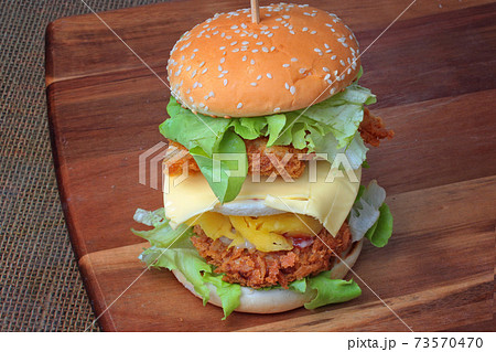 Double stacked crispy fried chicken burger recipe as sunny egg,cheese,mayonnaise, tomato sauce and lettuce. Double stacked crispy fried chicken burger recipe as sunny egg,cheese,mayonnaise, tomato sauce and lettuce. 73570470