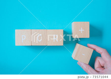 PCR検査の結果が陰性 | 「PCR」「+」「-」と書かれた積み木ブロックとそれをつまむ手 73571044