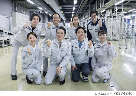 工場内でガッツポーズをする大人数の作業員 工場内でガッツポーズをする大人数の作業員 73574846