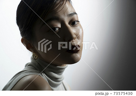 光と影のドラマティックな女性ポートレート 73575430