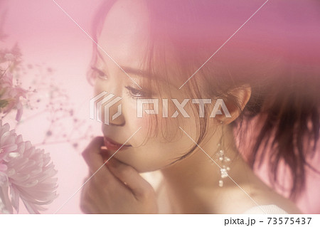 花を持つフェミニンな女性のポートレート 花を持つフェミニンな女性のポートレート 73575437