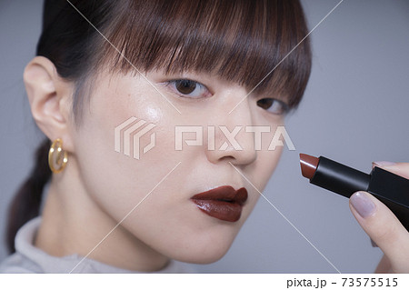ブラウンリップを塗る女性の写真素材 ブラウンリップを塗る女性の写真素材