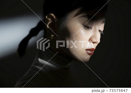光と影のドラマティックな女性ポートレート 73575647