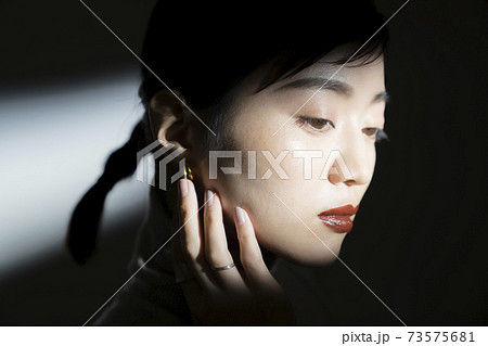 光と影のドラマティックな女性ポートレート 73575681