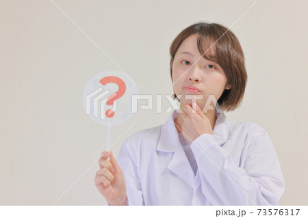 ？のプレートを持つ看護士 73576317