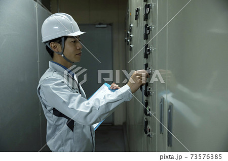 工場を点検する作業員男性　配電盤操作 73576385