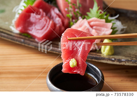 本鮪の赤身の刺身を醤油につける 本鮪の赤身の刺身を醤油につける 73578330