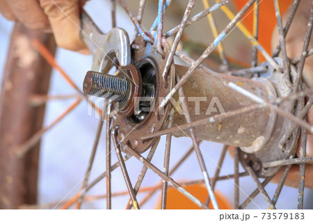 Close up of human hand, using a repair tool on the wheel. 73579183