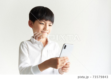 スマホの画面を見つめている男の子 73579843