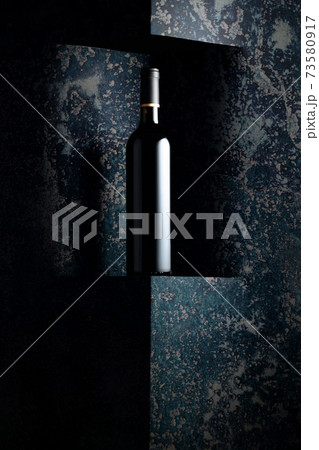 Unopened bottle of red wine on a background of old wall. Unopened bottle of red wine on a background of old wall. 73580917