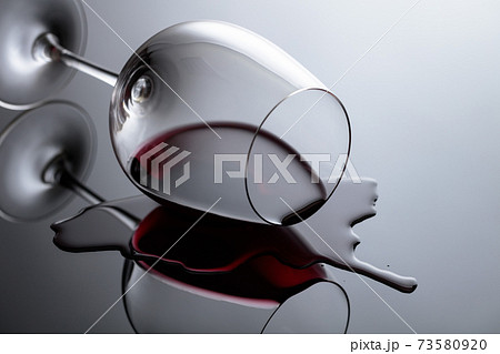 Glass of red wine on a black reflective background. Glass of red wine on a black reflective background. 73580920