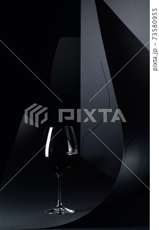 Glass of red wine on a black background. 73580955