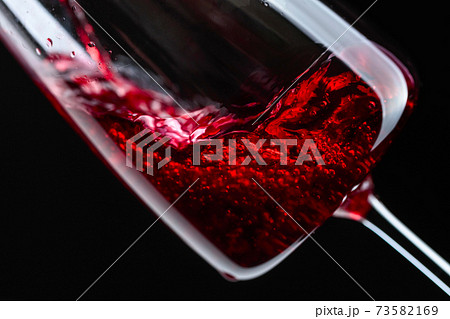 Red wine being poured into wineglass. Red wine being poured into wineglass. 73582169