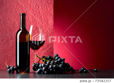 Blue grapes and red wine on a black table. Blue grapes and red wine on a black table. 73582257