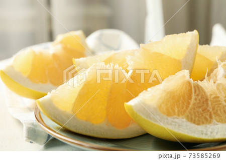 Kitchen towel and plate with pomelo slices, close up 73585269
