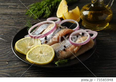 Concept of tasty lunch with herring fish on wooden background Concept of tasty lunch with herring fish on wooden background 73585948