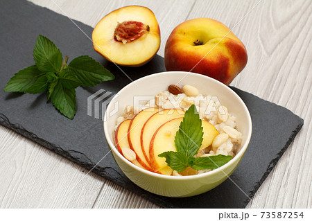 Sorghum salad with nuts and fresh peach on stone board. Sorghum salad with nuts and fresh peach on stone board. 73587254