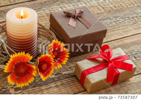 Gift boxes, candle and fresh flowers on wooden table. Gift boxes, candle and fresh flowers on wooden table. 73587307